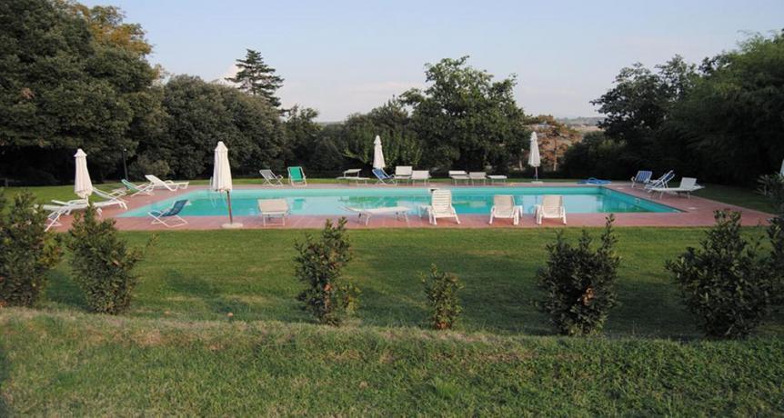 Piscina con ombrelloni e sdraio