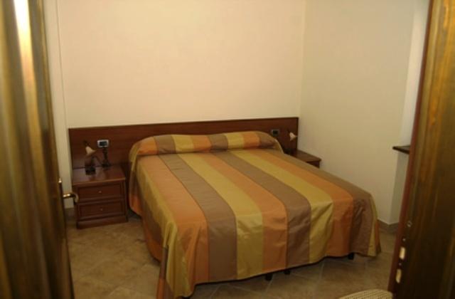 Camera con letto matrimoniale in arredamento rustico