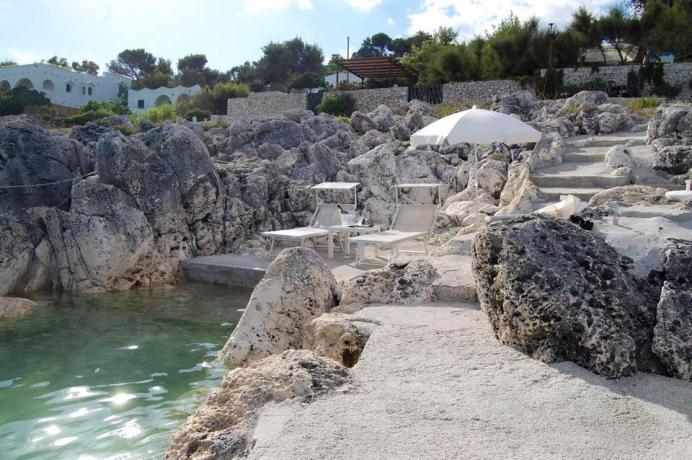 Spiaggia con Lettini e Ombrelloni tra gli scogli. 