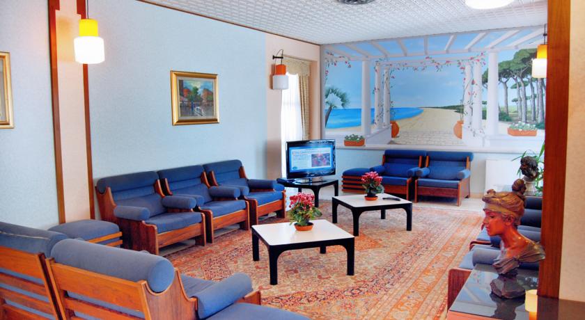 Salone comune con poltrone e TV
