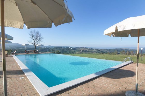 Piscina con ombrelloni e sdraio