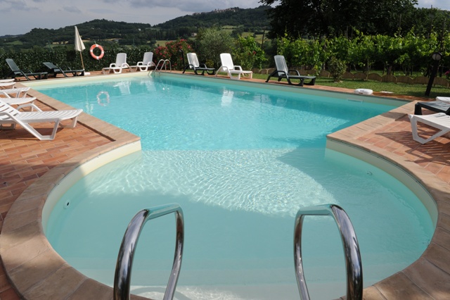 Piscina attrezzata con sdraio e ombrelloni 