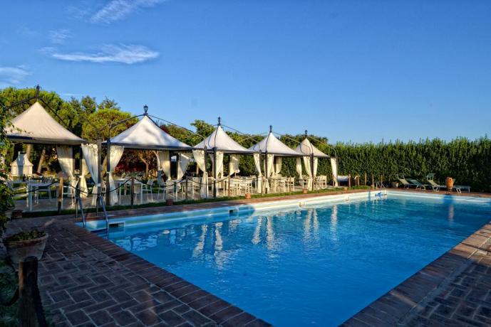 Piscina del casale attrezzata con sdraio e ombrelloni 