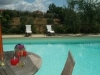 Piscina attrezzata con comodi lettini e sedie
