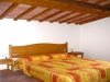 Camera da letto con travi a soffitto Lallo