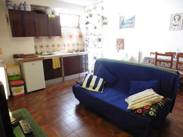 Soggiorno con divano letto matrimoniale e cucina attrezzata