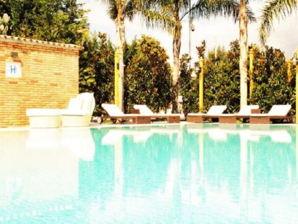 Piscina attrezzata con sdraio e ombrelloni