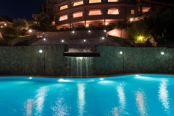 Piscina con piccola cascata illuminata