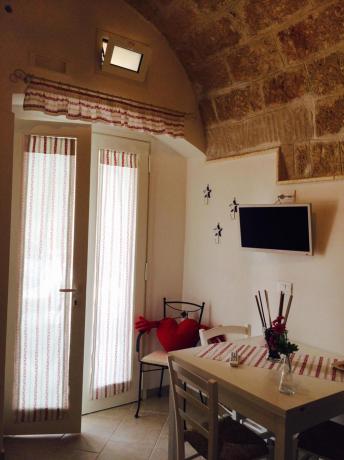 Salone con tavolo e tv casa-vacanze 4posti-letto polignano-a-mare