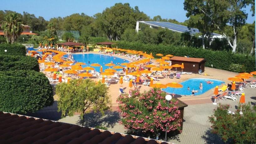 Villaggio con piscina con ombrelloni e lettini