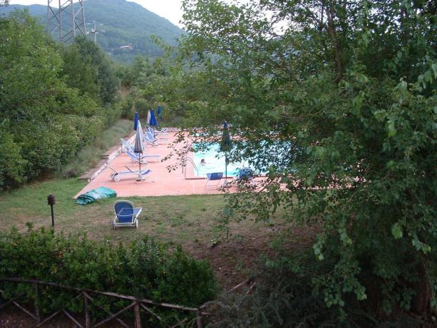 Piscina all'aperto con sdraio e ombrelloni 