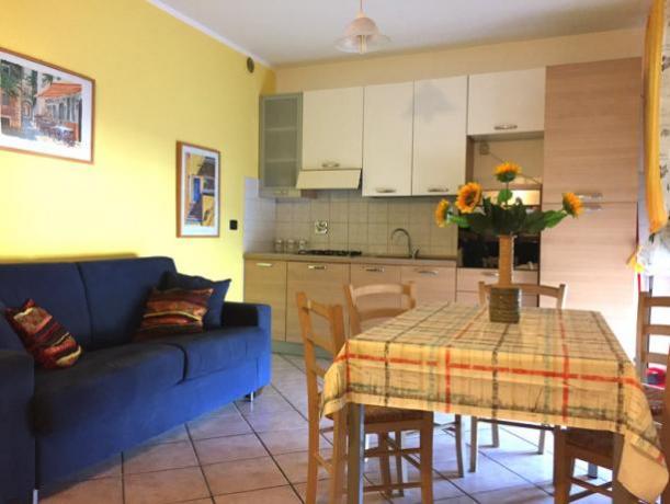 Soggiorno con divano, cucina, terrazza