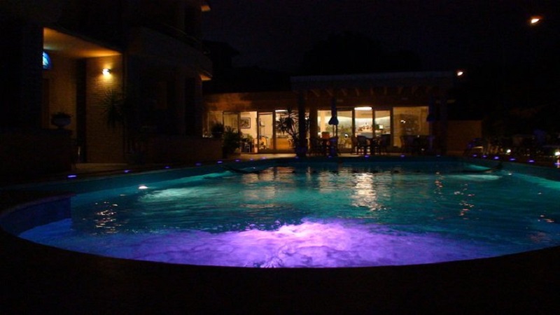 Piscina esterna di notte, residence nel Conero  