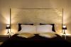 Junior Suite 11, letto con testiera in pietra	